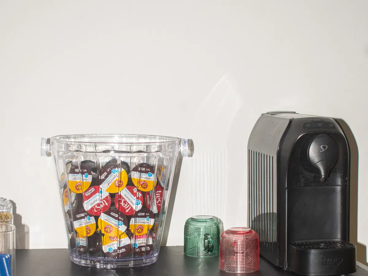 Cafeteira e cápsulas de café por conta da casa